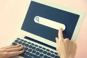 Hand auf der Laptop-Tastatur mit Suchleiste &ndash; Symbolbild daf&uuml;r, wie die Google-Suche funktioniert