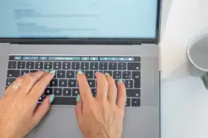 H&auml;nde tippen auf der Tastatur eines Laptops, Symbolbild f&uuml;r eine Anfrage &uuml;ber das Kontaktformular