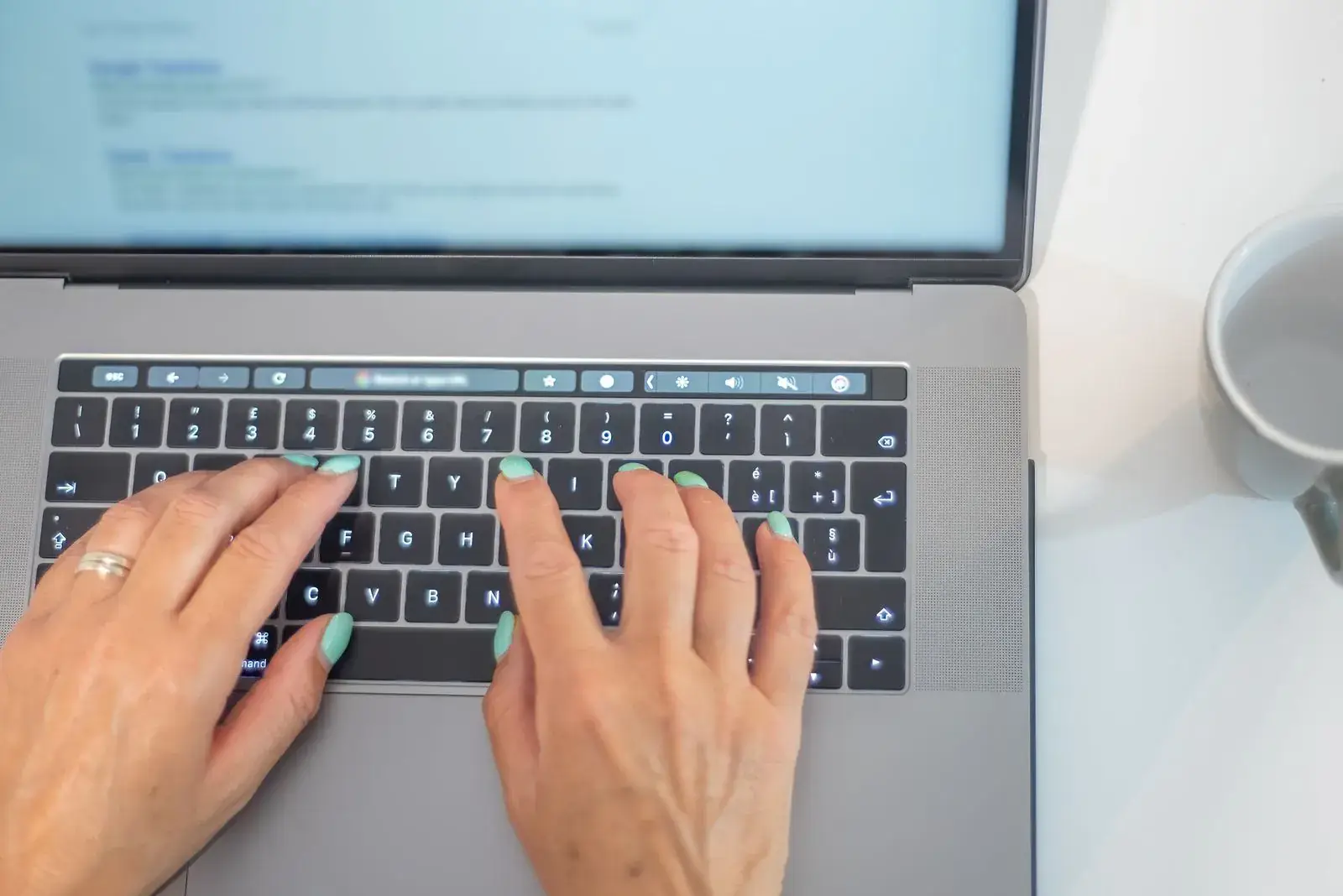 Hände tippen auf der Tastatur eines Laptops, Symbolbild für eine Anfrage über das Kontaktformular