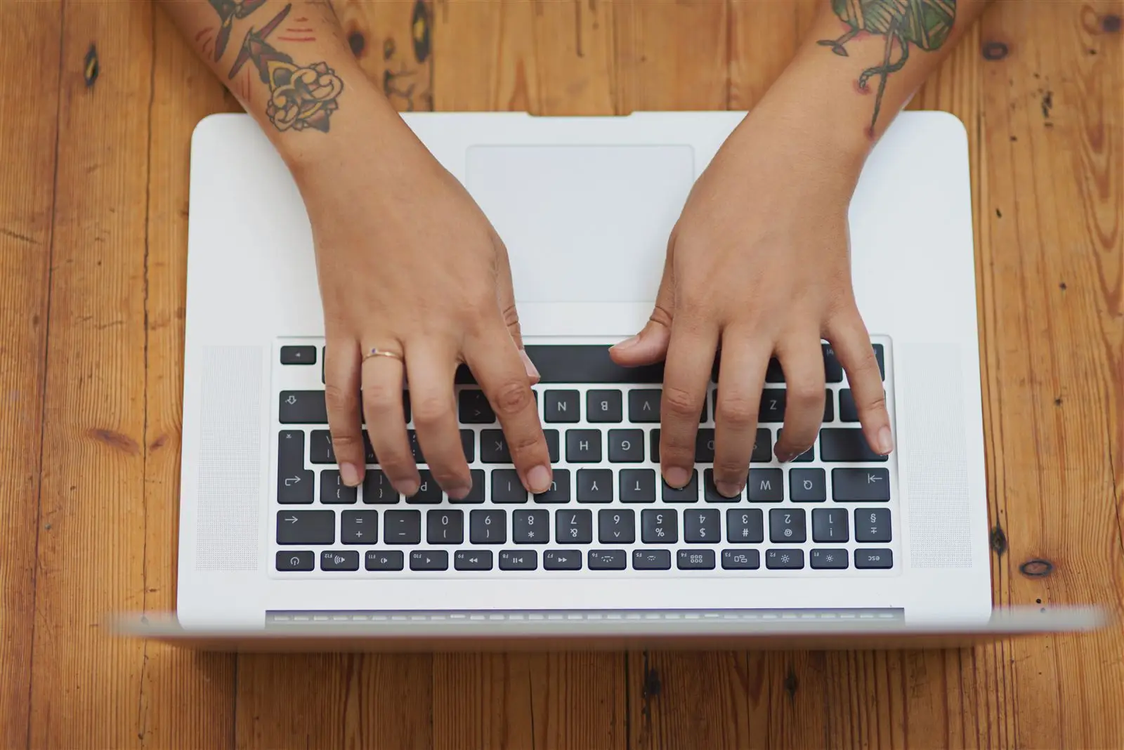 Hände tippen auf einer Laptop-Tastatur – Symbolbild für das Schreiben einer Leistungsseite