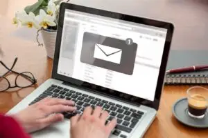 Hand am Laptop mit neuer E-Mail im Posteingang – Symbolbild für Newsletter kleiner Betriebe