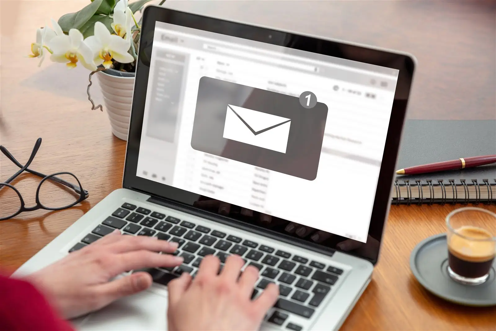 Hand am Laptop mit neuer E-Mail im Posteingang – Symbolbild für Newsletter kleiner Betriebe