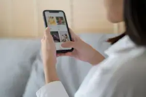 Frau scrollt auf dem Smartphone durch Produktbilder, Symbolbild f&uuml;r Retargeting