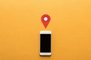 Smartphone mit Standortmarkierung auf orangefarbenem Hintergrund &ndash; Symbolbild f&uuml;r Beitr&auml;ge im Google-Unternehmensprofil