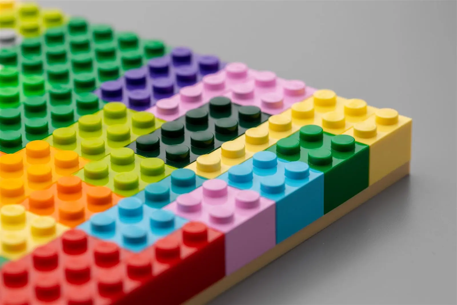Bunte Kunststoff-Bausteine auf grauem Hintergrund – Symbolbild für WordPress oder Website-Baukasten